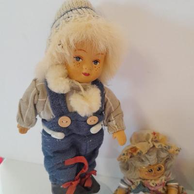 Two collectible dolls with stands, small wooden decorative box and some jewelry