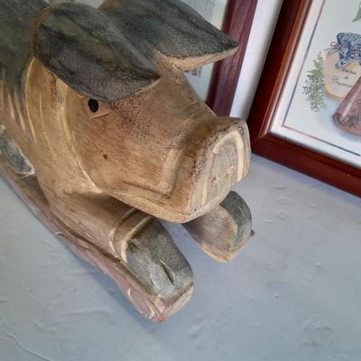 Two framed wall art and a wooden rocking pig decoration