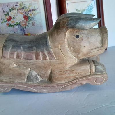 Two framed wall art and a wooden rocking pig decoration