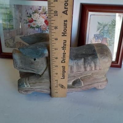 Two framed wall art and a wooden rocking pig decoration