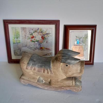 Two framed wall art and a wooden rocking pig decoration