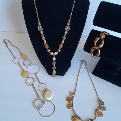 Three fashion necklaces and a gold-colored metal bracelet