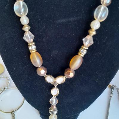 Three fashion necklaces and a gold-colored metal bracelet