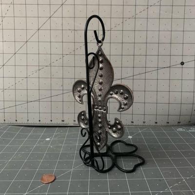 Fleur de lis sculpture on a stand