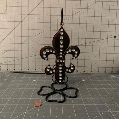 Fleur de lis sculpture on a stand