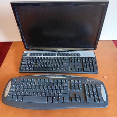 The Acer P243w Monitor With 2 keyboards