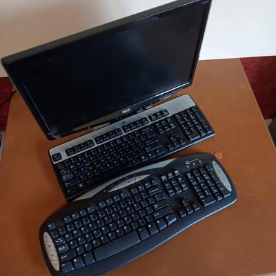 The Acer P243w Monitor With 2 keyboards