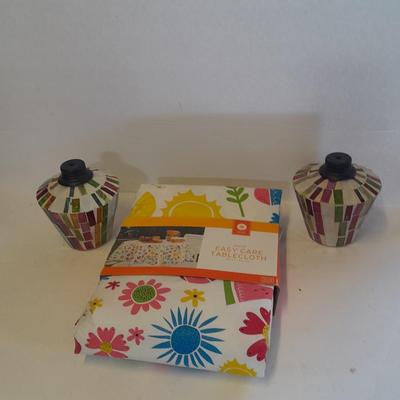 Two colored glass oil lamps with a new tablecloth