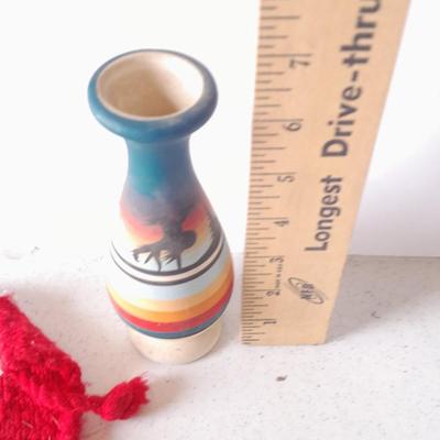Signed pottery vase with Native dolls and Native. table throw rug