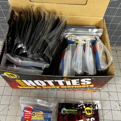 Box full of Space Blankets and Hotties Hand Warmers 