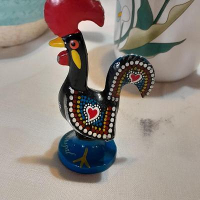 Blue pitcher with bee, coffee mug, metal rooster decor, and glasses with embroidered linen table runner