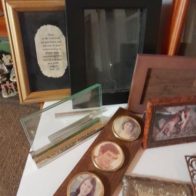 Variety of picture frames, some wood, some metal