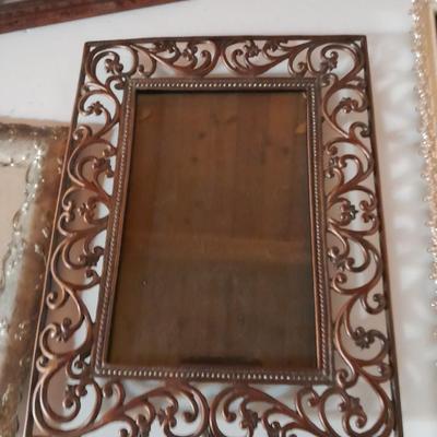 Variety of picture frames, some wood, some metal