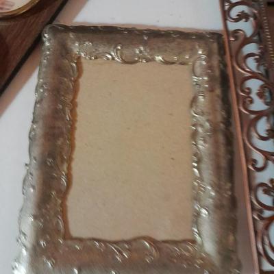 Variety of picture frames, some wood, some metal