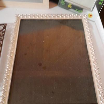 Variety of picture frames, some wood, some metal