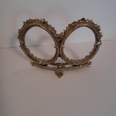 Vanity top mirror with gold rim, brass lidded jars and a compact