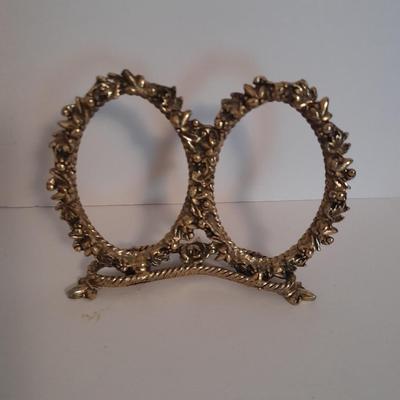 Vanity top mirror with gold rim, brass lidded jars and a compact
