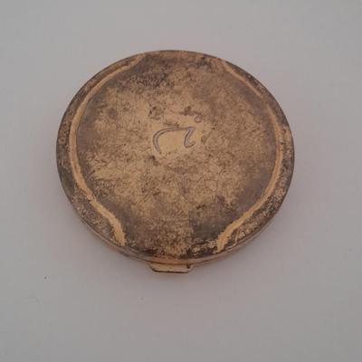 Vanity top mirror with gold rim, brass lidded jars and a compact