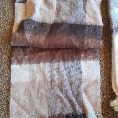 Brown toned winter wear, two scarves, an umbrella, fluffy socks, and a pair of gloves