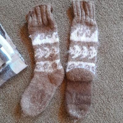 Brown toned winter wear, two scarves, an umbrella, fluffy socks, and a pair of gloves