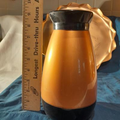 Copper and copper toned hot and cold pitchers on copper platter