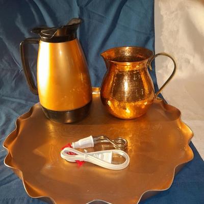 Copper and copper toned hot and cold pitchers on copper platter