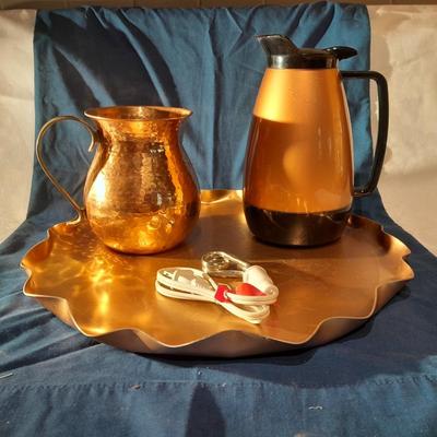 Copper and copper toned hot and cold pitchers on copper platter
