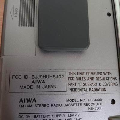 Portable Sony CD Car Discman with remote and vehicle attachments, a pair of Realistic speakers with case, and a Aiwa Walkman