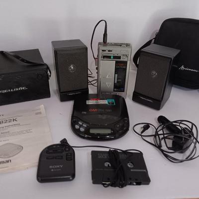 Portable Sony CD Car Discman with remote and vehicle attachments, a pair of Realistic speakers with case, and a Aiwa Walkman
