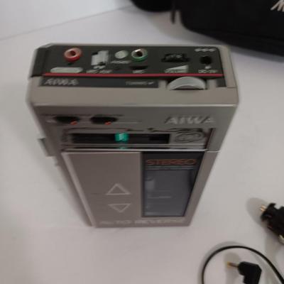 Portable Sony CD Car Discman with remote and vehicle attachments, a pair of Realistic speakers with case, and a Aiwa Walkman