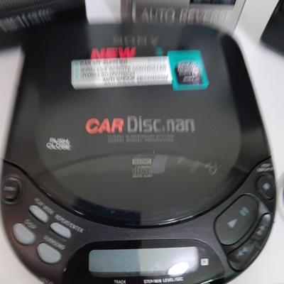 Portable Sony CD Car Discman with remote and vehicle attachments, a pair of Realistic speakers with case, and a Aiwa Walkman