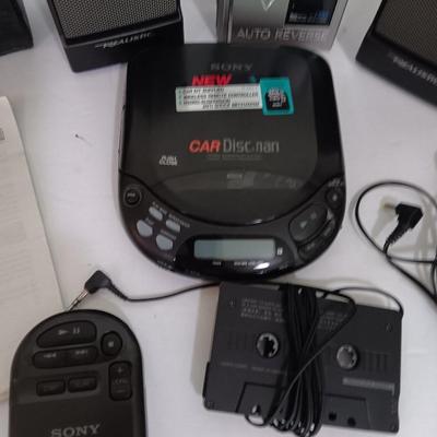 Portable Sony CD Car Discman with remote and vehicle attachments, a pair of Realistic speakers with case, and a Aiwa Walkman