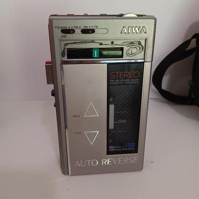 Portable Sony CD Car Discman with remote and vehicle attachments, a pair of Realistic speakers with case, and a Aiwa Walkman