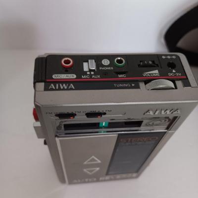 Portable Sony CD Car Discman with remote and vehicle attachments, a pair of Realistic speakers with case, and a Aiwa Walkman
