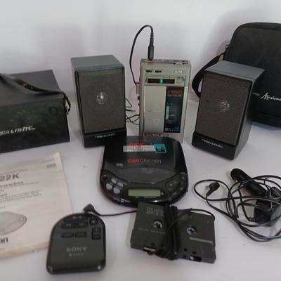 Portable Sony CD Car Discman with remote and vehicle attachments, a pair of Realistic speakers with case, and a Aiwa Walkman