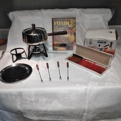 Fondue set pot, burner, and servers with Fondue and tabletop cooking cookbook.