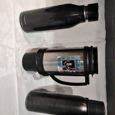 Stanley travel mug and two metal water bottles