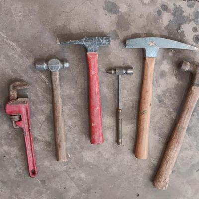 Assortment of hammers for different uses and a pipe wrench