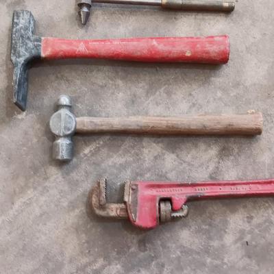 Assortment of hammers for different uses and a pipe wrench