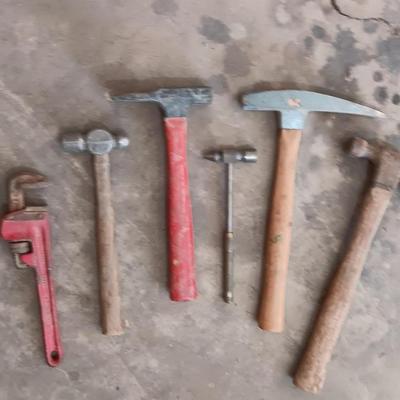 Assortment of hammers for different uses and a pipe wrench