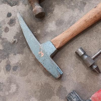 Assortment of hammers for different uses and a pipe wrench