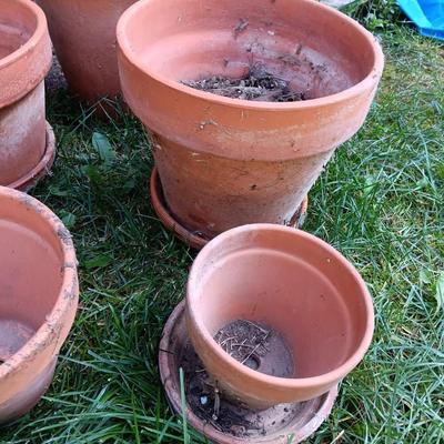 Five different sized terra cotta clay pots and some water saucers