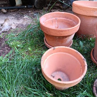 Five different sized terra cotta clay pots and some water saucers