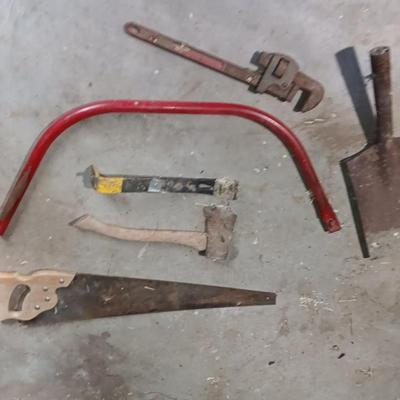 Assortment of hand tools - saws- pipe wrench - hatchet- and more
