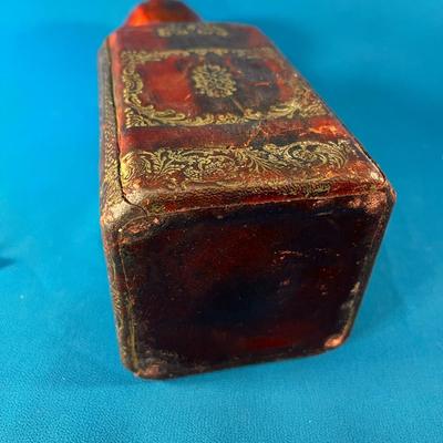 MYSTERIOUS LEATHER COVERED GLASS JAR WITH STOPPER AND METALLIC CREST 