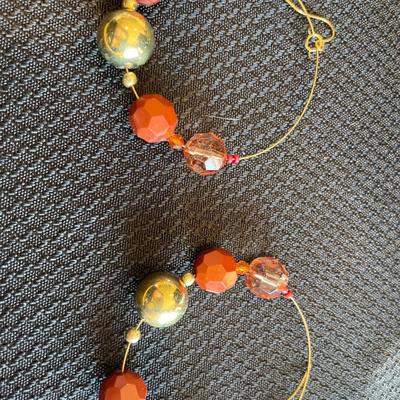 2 green, 1 golden/brown color necklaces