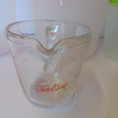 Three plastic lidded food storage containers with Fire King measuring glass