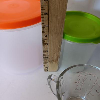 Three plastic lidded food storage containers with Fire King measuring glass