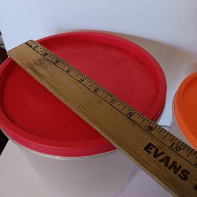 Three plastic lidded food storage containers with Fire King measuring glass