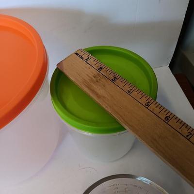 Three plastic lidded food storage containers with Fire King measuring glass